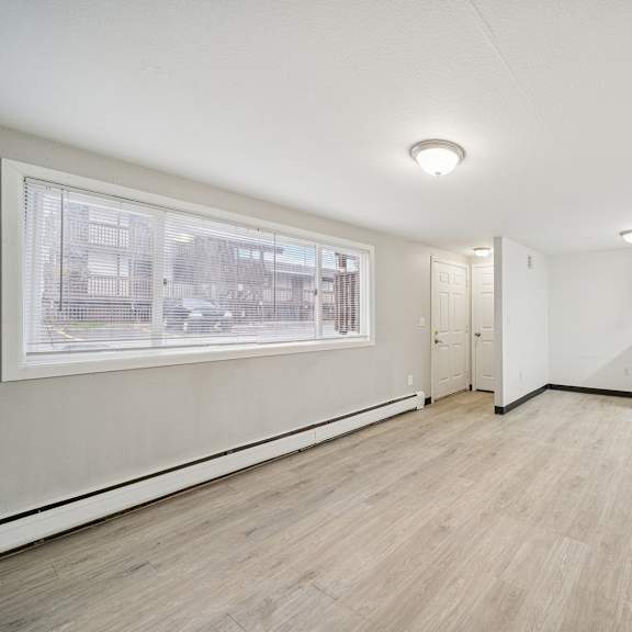 a room with a window and a white cabinet.