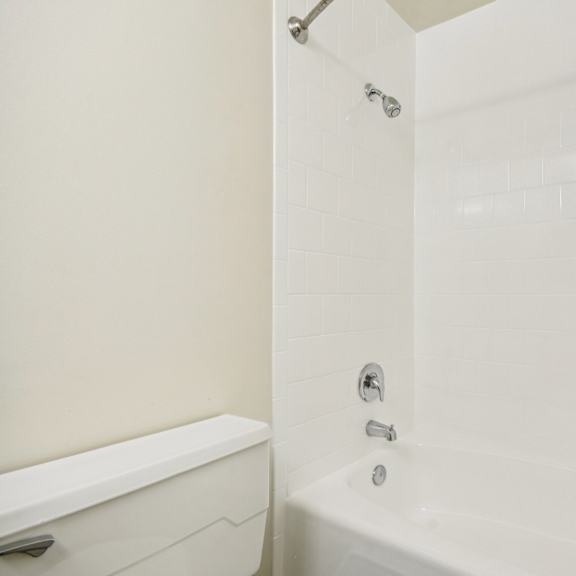 a white bathroom with a tub and shower.