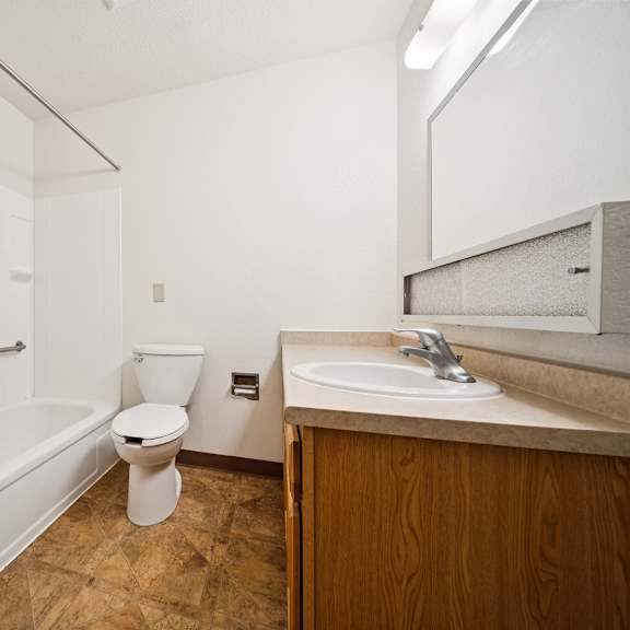 a white bathroom with a toilet, sink, and bathtub.