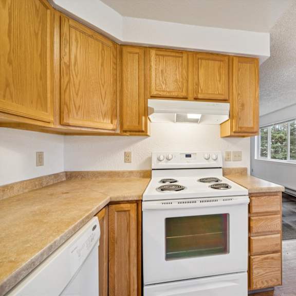 a kitchen with wooden cabinets and a white stove top oven.
