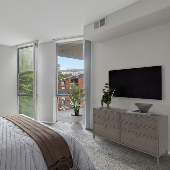 a bedroom with a large bed, a television, and a window overlooking a garden.