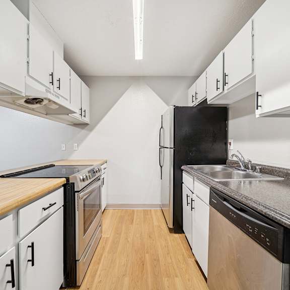 a kitchen with black appliances and white cabinets.