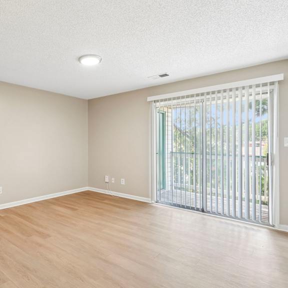 a room with wooden floors and a sliding glass door.