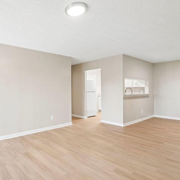a room with light wood flooring and white walls.