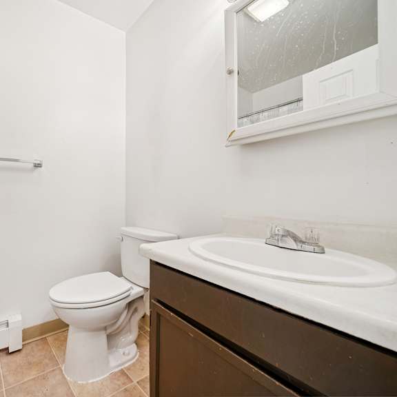a white toilet sits next to a white sink in a bathroom.