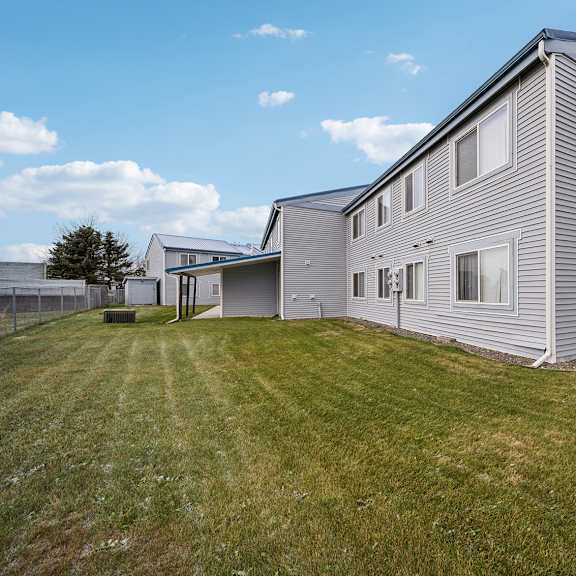 a row of houses with a green lawn in front.