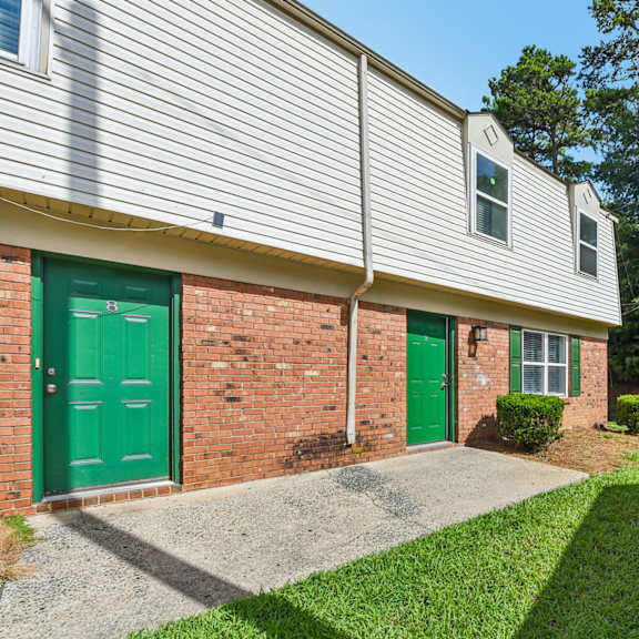 a building with a green door and a grey roof.