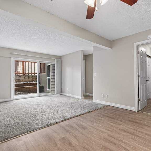 a room with a ceiling fan and a doorway leading to another room.