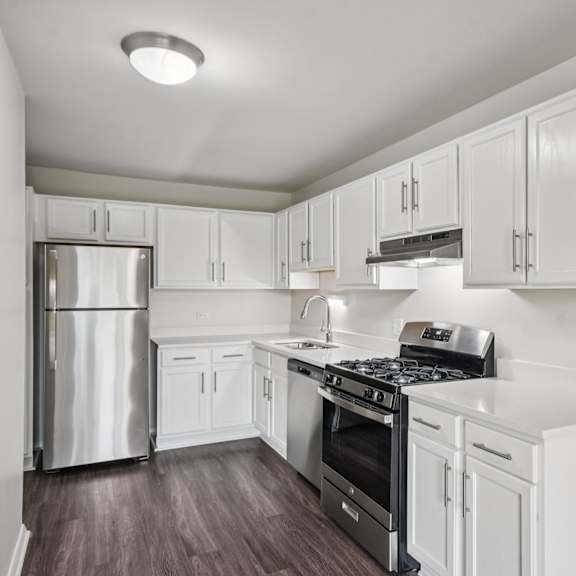 a kitchen with white cabinets and a stainless steel refrigerator.