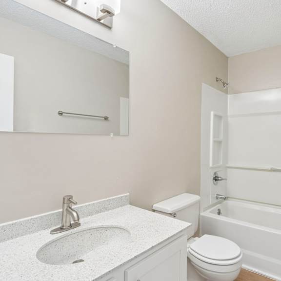 a white toilet sits next to a sink in a bathroom.