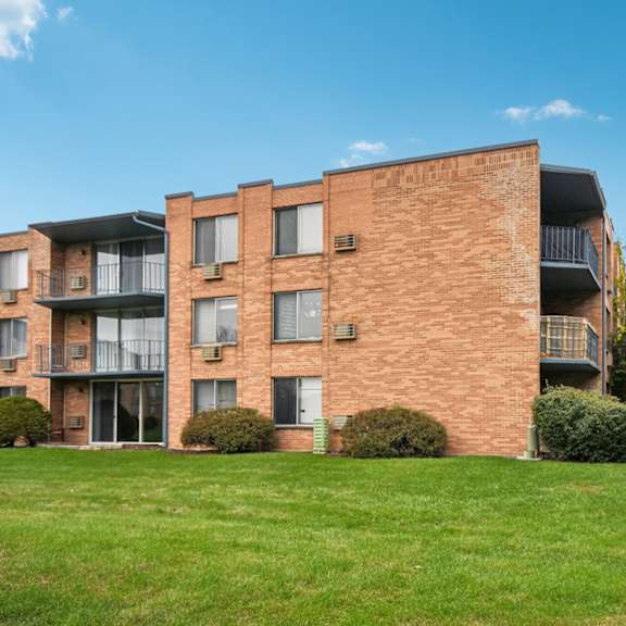 a red brick building with a balcony on the second floor.