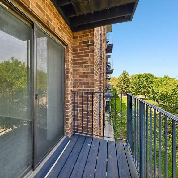 a balcony with a glass door and a metal railing.