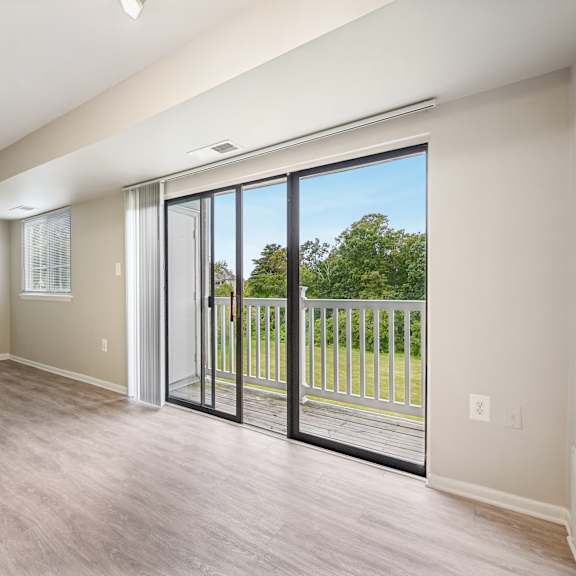 an empty living room with sliding glass doors to a balcony at renew odenton