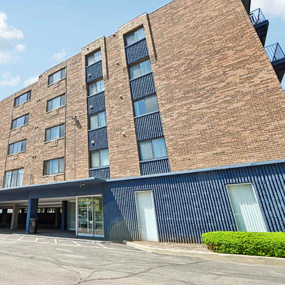 a large brick building with a parking lot in front.