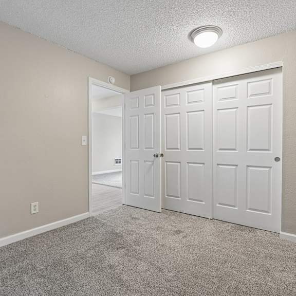 a room with a white door and carpeted floor.