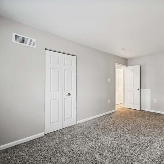 an empty room with white doors and a carpeted floor at renew odenton
