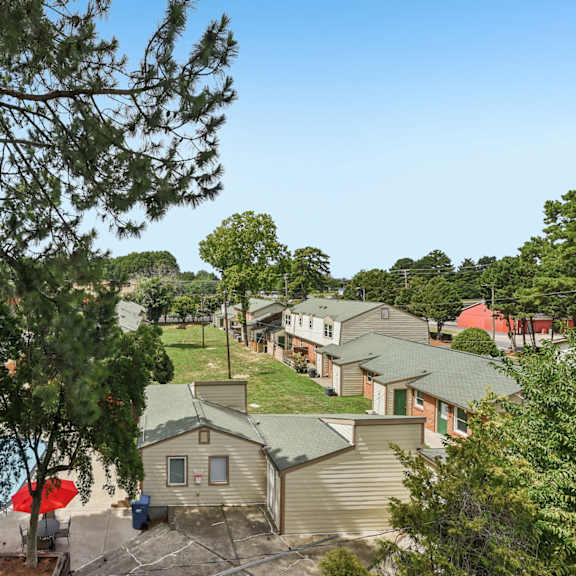 a pool surrounded by trees and apartment buildings.