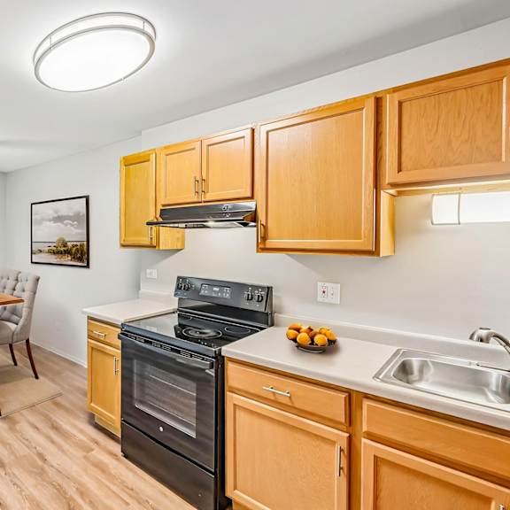 a kitchen with wooden cabinets and a black oven.