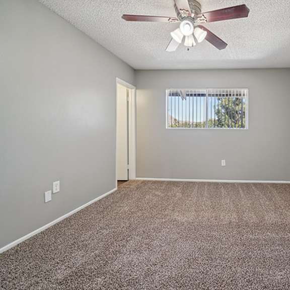 a room with a ceiling fan and carpeted floor.