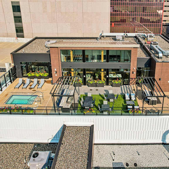 a rooftop patio with a pool and seating area.