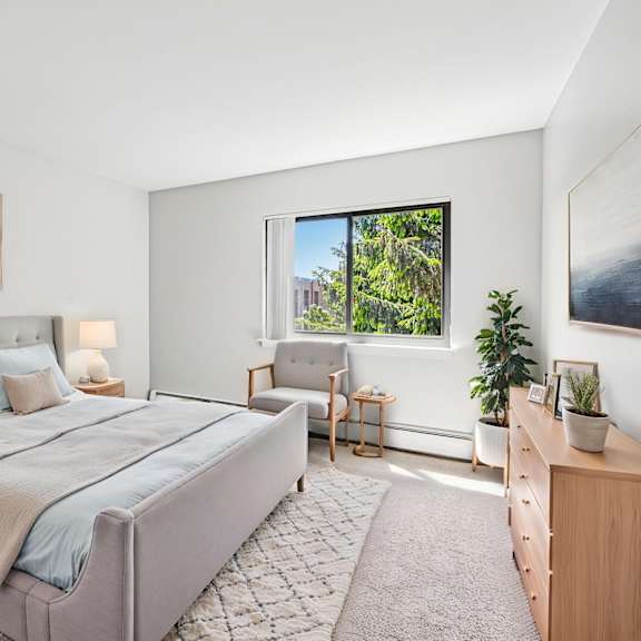 a bedroom with a large bed and a view of the outdoors through a window.