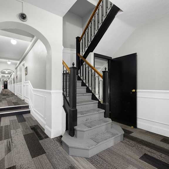 a long hallway with a staircase on the right at pleasant oak apartments, oak park, illinois