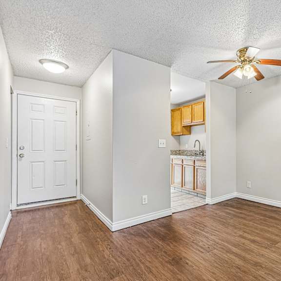 a room with a ceiling fan and wooden flooring.