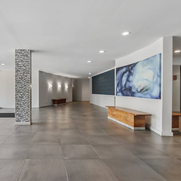 a hallway with a stone pillar and a large painting on the wall.