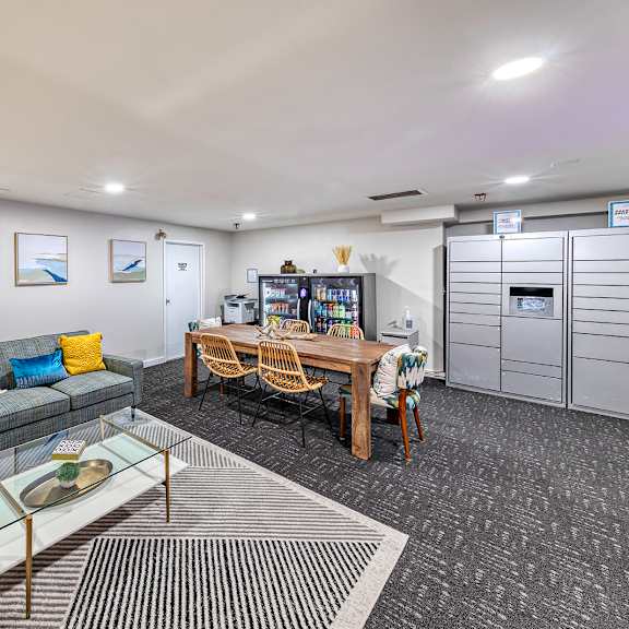 room with a grey couch, a glass coffee table, and a wooden dining table with chairs. at oak park city, oak park, il