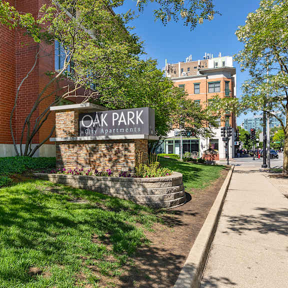 a sign for oak park apartments is in front of a brick building. at oak park city, oak park illinois