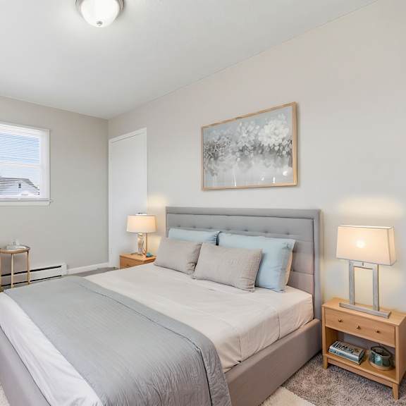 a bedroom with a large bed, a chair, and a nightstand.