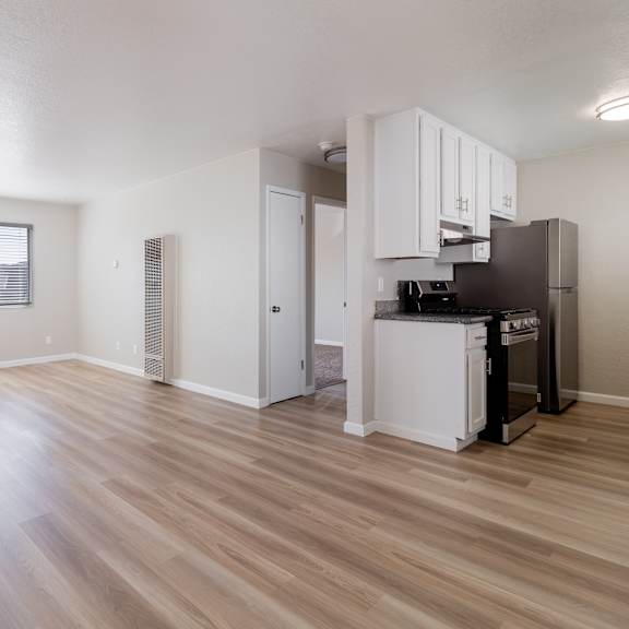 the living room and kitchen of an apartment with a hard wood floor at alturas paso robles apartment homes, paso robles, ca