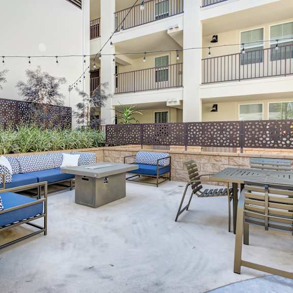 a patio with a table and chairs and a building in the background