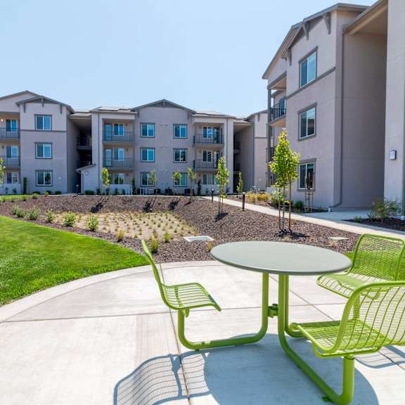 a green chair and table are in the foreground of a residential area.