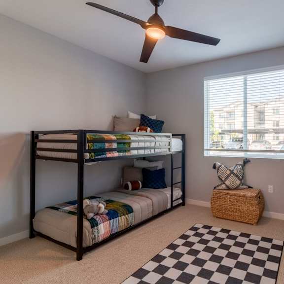 a room with a bunk bed and a black and white checkered rug.