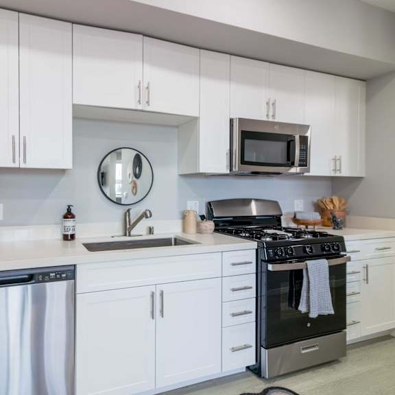a modern kitchen with white cabinets and stainless steel appliances.