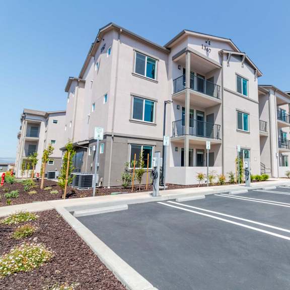 a parking lot in front of apartment buildings with a sign that says