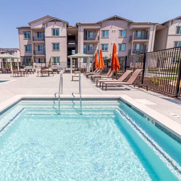 a swimming pool in front of apartment buildings.