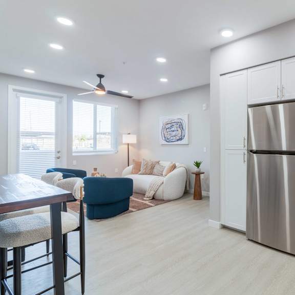 a modern kitchen with a stainless steel refrigerator and white cabinets.