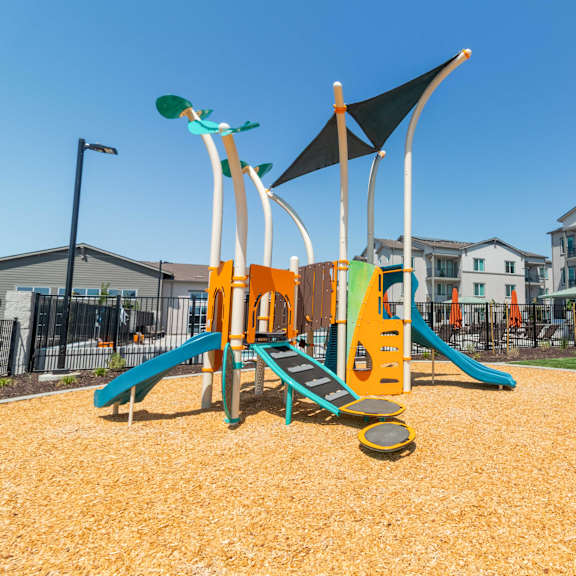 kids playground with slides and apartment buildings in the background