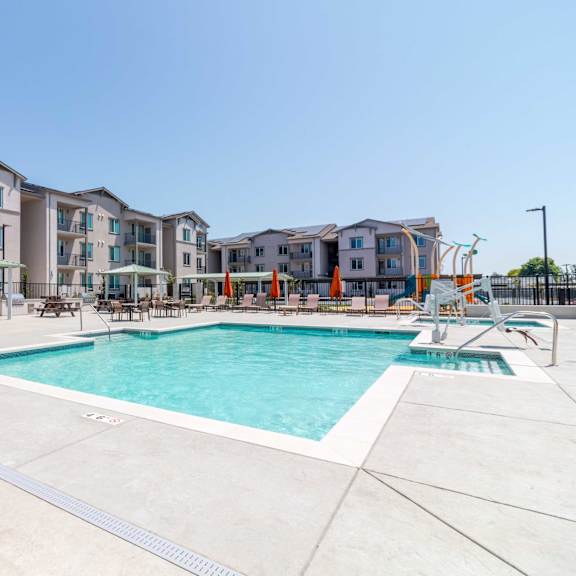 a large swimming pool in front of apartment buildings.