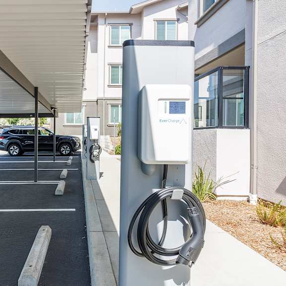 a charging station for electric vehicles is located under a covered parking area.