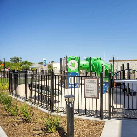 kids playground with a slide surrounded by a fence