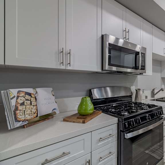 a modern kitchen with a stove, microwave, and oven.