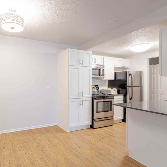 a kitchen with white cabinets and a black countertop.