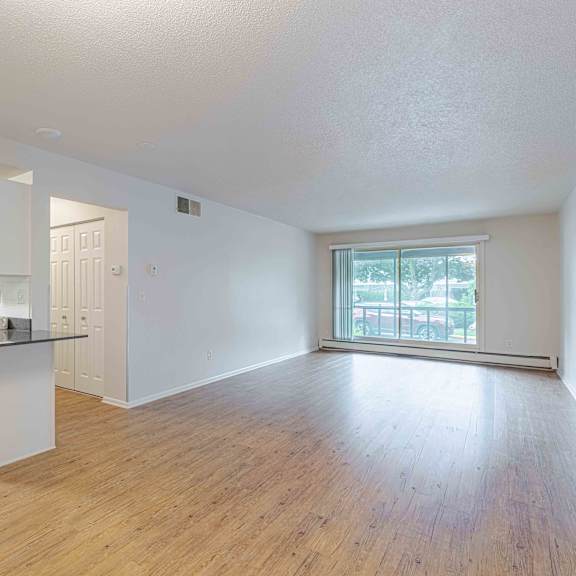 a kitchen with white cabinets and a wooden floor.