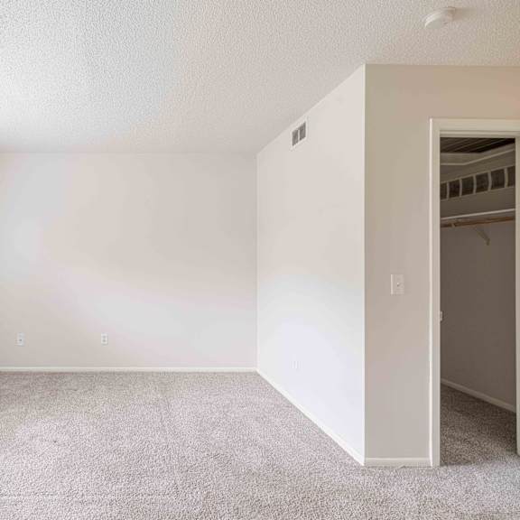 a room with a carpeted floor and a window on the left side.