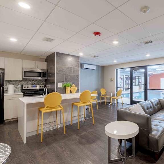 a modern living room with a kitchen area in the background.