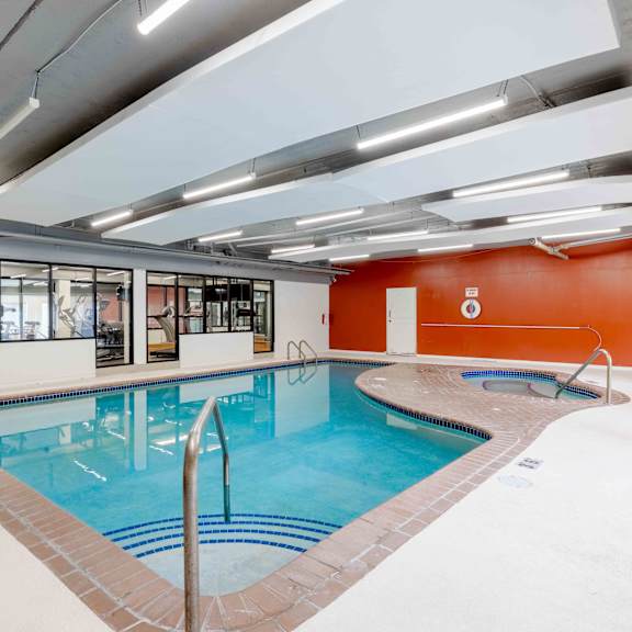 a large indoor swimming pool with a glass wall on one side.