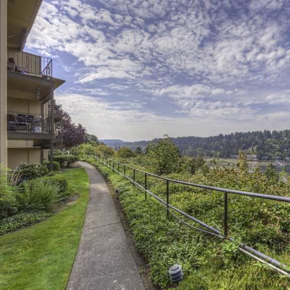a walkway next to a building with a view of a river and trees at overlook at the willamette, milwaukie, or ?